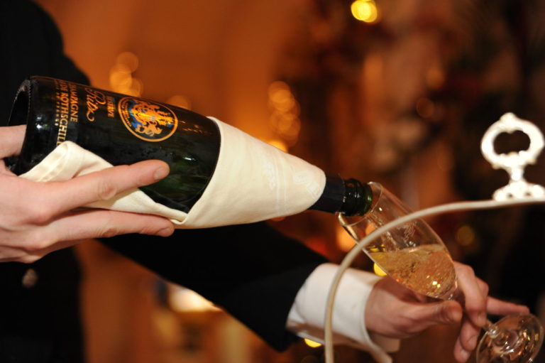 Miss Windsor's Delectables - Christmas Afternoon Tea at The Ritz, London. Waiter pours a glass of - Reserve Ritz Champagne Barons De Rothschild 